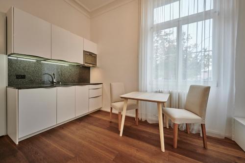 伯尔尼Perfect Location, comfortable & modern的厨房配有白色橱柜和桌椅