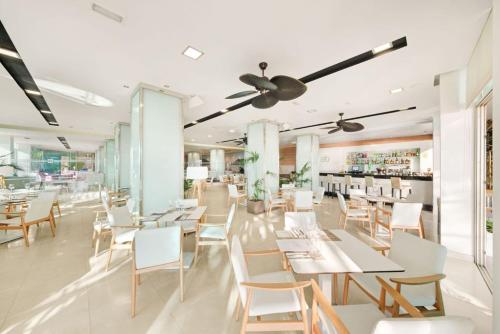 帕尔马诺瓦Hotel Agua Beach "Adults only"的一间设有白色桌椅的用餐室