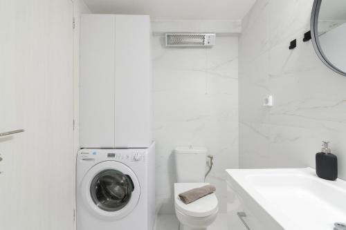 瓦尔基扎Apartment For 3 Ppl In Varkiza的白色的浴室设有洗衣机和卫生间。