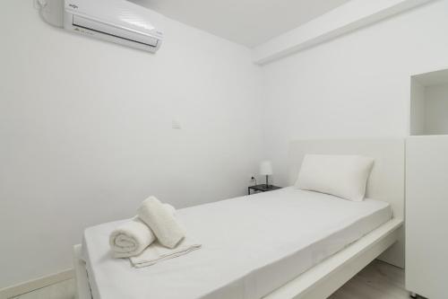 瓦尔基扎Apartment For 3 Ppl In Varkiza的白色客房内的白色床,上面有毛巾