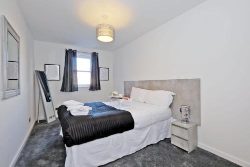 阿伯丁Orange Apartments Belgrave Mansions的卧室配有一张白色的大床和一张桌子