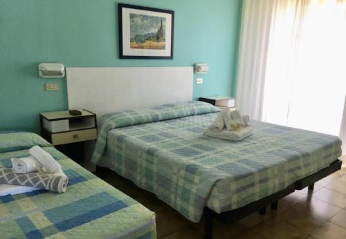 里米尼Hotel Bonaria的一间卧室配有两张带毛巾的床