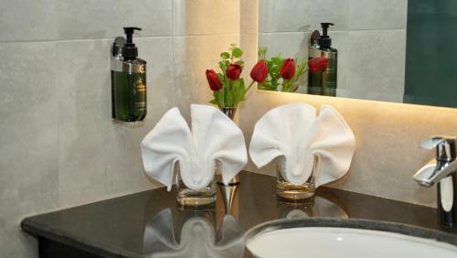 塞拉莱KYRIAD HOTEL SALALAH的浴室水槽和柜台上的2条白色毛巾