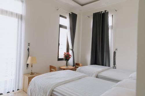 大叻Mai DiaMond Hotel的一间卧室设有两张床和窗户。