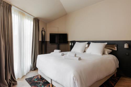 奥尔良La Loge Gogaille - Arago - Accès autonome的卧室配有白色大床和白色枕头