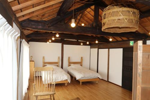 玉野市Womb Guesthouse Kojima -Uminomieru ie- - Vacation STAY 95107v的客房设有两张床,配有木制天花板和木地板。