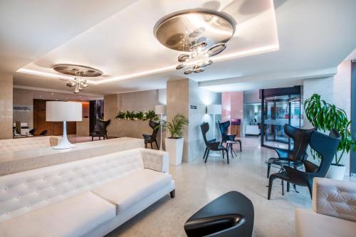 巴统Alliance Palace Batumi的客厅配有白色的沙发和椅子
