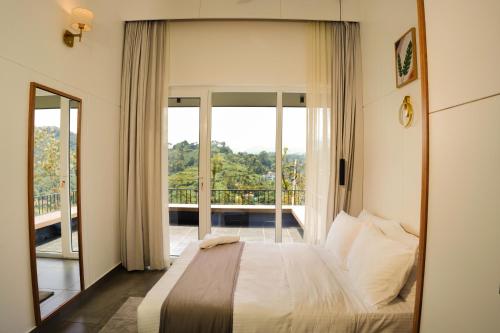 维特利Leaves Resort Vythiri Wayanad的一间卧室设有一张床和一个阳台