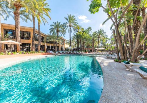 埃尔切治愈花园酒店的棕榈树和椅子的度假村的游泳池