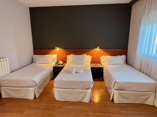 马德里AP Hotel Madrid Airport的客房设有两张床和一张书桌。
