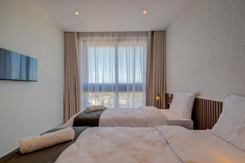 Is-SwieqiMayfair by Premier Suites MT的酒店客房设有两张床和窗户。