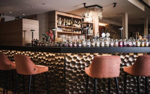 圣维吉利奥Excelsior Dolomites Life Resort的吧台前有三把凳子的酒吧
