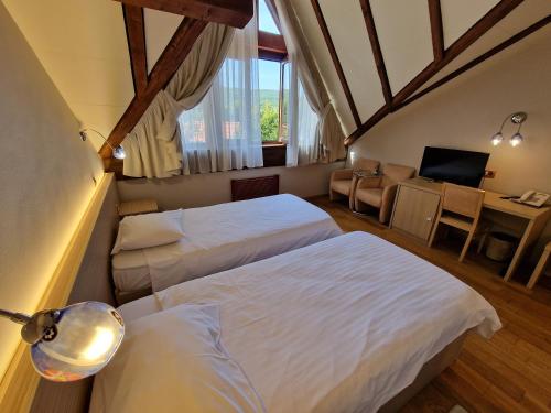克卢日-纳波卡阳光山峰酒店的酒店客房带两张床、书桌以及一间客房。