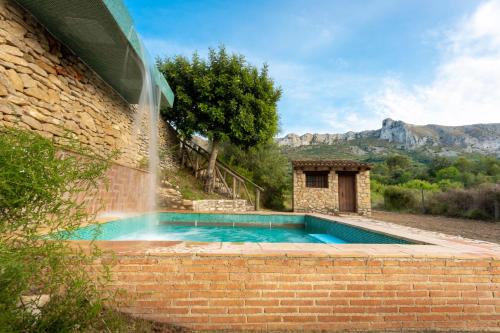 BenisiliCasa Rural Ca Ferminet & Cabañas de montaña La Garriga的一座游泳池,一座建筑中有一个喷泉