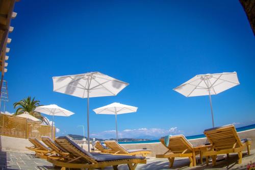 阿凯松阿拉斯住宿加早餐旅馆的海滩上的一组椅子和遮阳伞