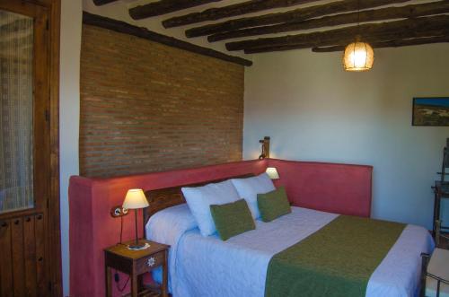 VálorBalcón de Válor的一间卧室设有一张床和砖墙