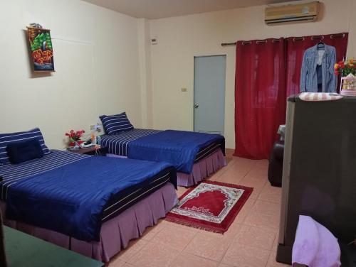 芭堤雅市中心Pattaya inn By Thai Smile的一间卧室设有两张床和红色窗帘