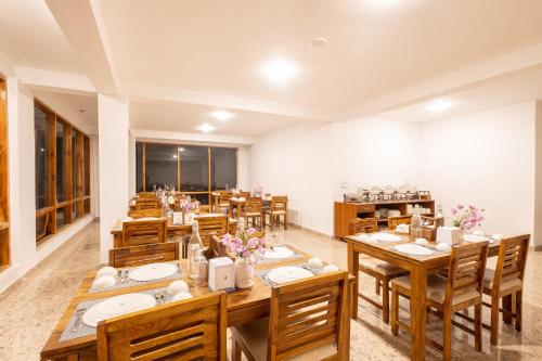马拉里Aroha Residency- A Countryside Resort的大型用餐室配有木桌和椅子