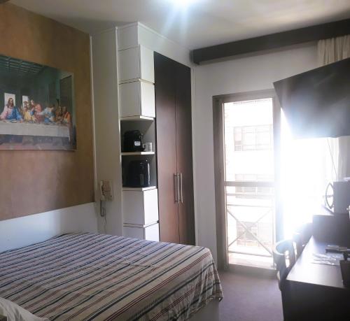 南圣卡埃塔诺O Melhor Apart-Hotel, da Cidade!的一间卧室配有一张床,一扇门设有窗户