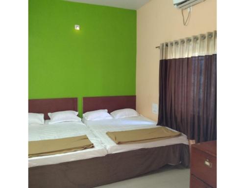 索姆纳特Hotel Shree, Somnath的一间卧室设有两张床和绿色的墙壁