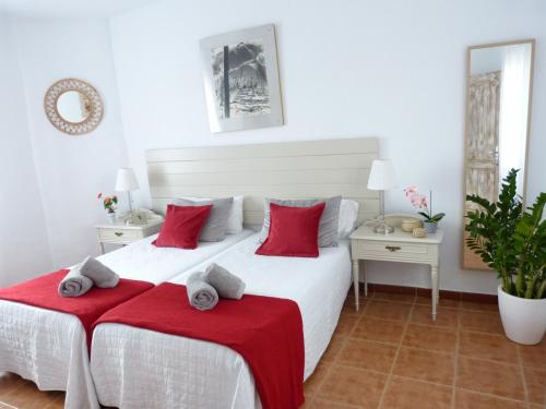 因赫尼奥Villa Alto Arena piscina privada climatizada的卧室配有带红色枕头的大型白色床