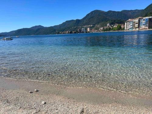 奥梅尼亚Canottieri home的一片水体,一片岩石海滩和山脉