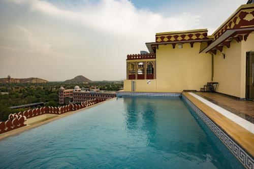 斋浦尔Umaid Haveli-A Heritage Style Hotel & Resort的建筑物一侧的游泳池