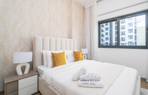 迪拜Nasma Luxury Stays - Home-Style 2BR Apartment with a Balcony View的卧室配有一张带黄色枕头的大型白色床。
