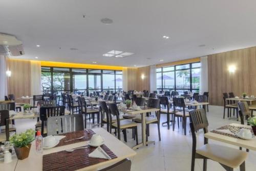 福塔莱萨Iate Plaza Flat 613的用餐室设有桌椅和窗户。