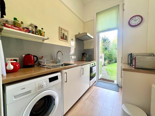 爱丁堡Beautiful Spacious Ground Floor Newington flat的厨房配有洗衣机和水槽