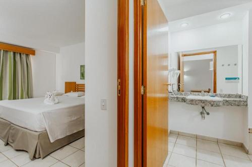 热河市Rio Quente Resorts - Hotel Giardino的一间卧室配有床、镜子和水槽