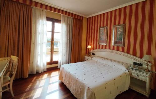 巴利亚多利德Hotel Conde Ansúrez的一间卧室设有一张大床和一个窗户。