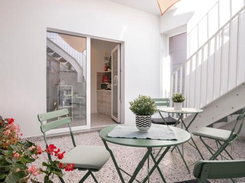 里米尼Zuara9Room Rimini的阳台配有2张桌子和椅子,楼梯
