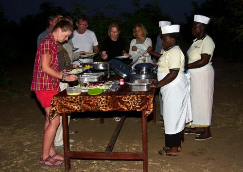KasenyiEuphorbia Safari Lodge的一群人站在桌子旁吃着食物