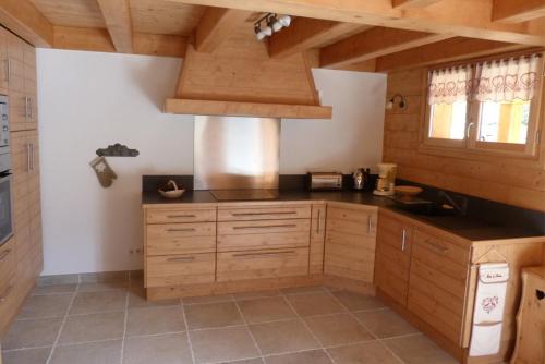 博福特Chalet ambiance montagne, 10 personnes, 4 chambres - CH15的一个带木制橱柜和炉灶的大厨房