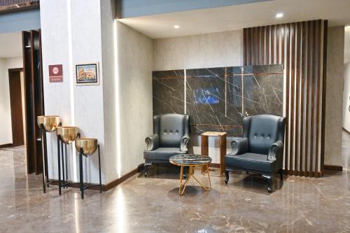 伊斯兰堡Jacaranda Heights的大楼内带两把椅子和一张桌子的大堂