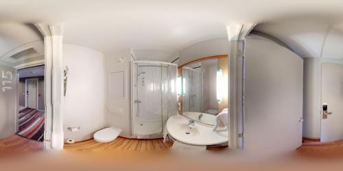 迪南迪南宜必思酒店的白色的浴室设有浴缸和水槽。