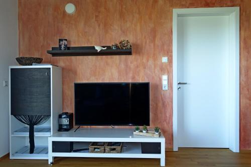 林登贝格Ferienwohnung VITA的一间客厅,客厅内配有一台电视,位于白色娱乐中心