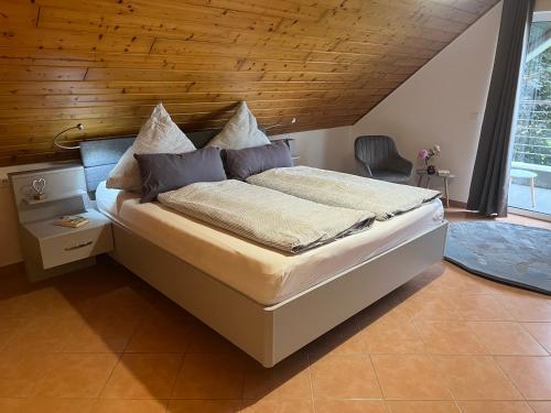 吕丁豪森Hof Dalhaus的一间卧室设有一张带木制天花板的大床