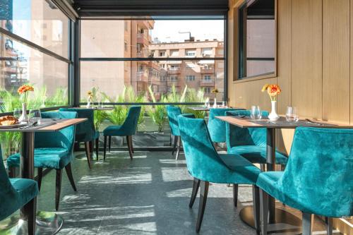 地拉那Central Inn Hotel的餐厅设有蓝色的桌椅和窗户。