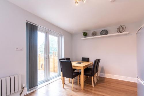 比斯顿2 Bedroom House in Chilwell - Perfect for Families and Business的一间带桌椅和窗户的用餐室