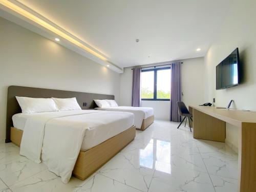 朱笃The Luxe Hotel Châu Đốc的酒店客房配有两张床和一张书桌