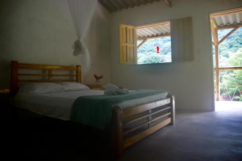 米卡Hostal Vista Verde Minca的一间卧室设有一张床和一个窗口