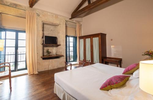 圣阿德里安德科夫雷斯雷克多罗科布1729酒店的卧室配有带粉红色枕头的大型白色床