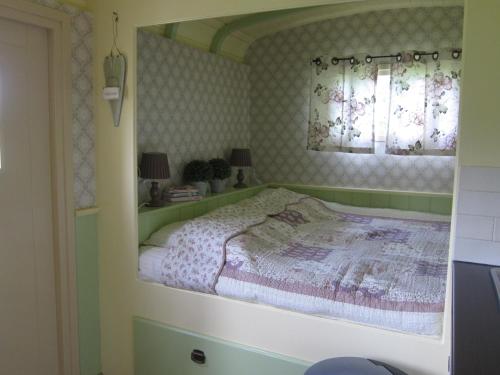 MerseloPipowagen Minicamping De Linde的一间卧室设有一张床和一个窗口