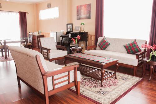 西隆Windermere Inn的客厅配有沙发、椅子和桌子