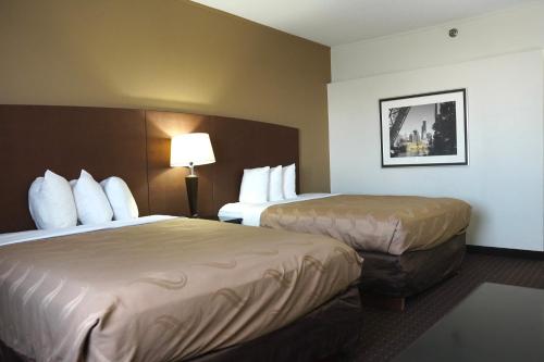 沃特福德镇American Inn & Suites的酒店客房,设有两张床和一盏灯