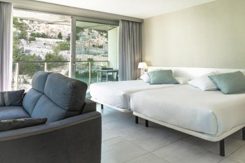 佩尼斯科拉阿哥拉Spa度假酒店的一间卧室设有两张床、一张沙发和一个窗口
