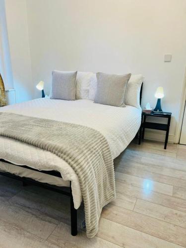 伦敦Comfy double room in Clapham的一间卧室配有一张大床,床上有毯子