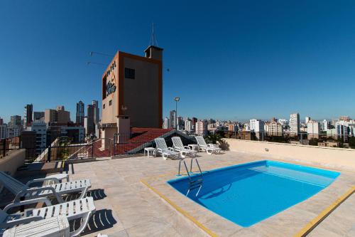 库里提巴Hotel Flat Petras Residence的建筑物屋顶上的游泳池